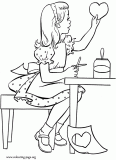 A little girl cutting and pasting a heart coloring page